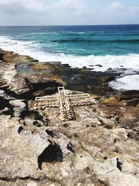 Scenic view of rocks on beach against sky