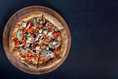 High angle view of pizza on table against black background