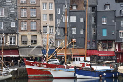 Boats moored in canal by buildings in city