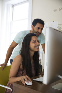 Couple using desktop computer at home