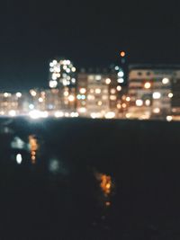 Defocused image of illuminated city buildings at night