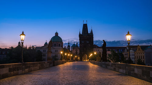 Illuminated buildings against sky at dusk