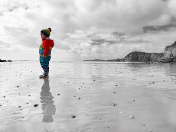 Full length of child on beach against sky