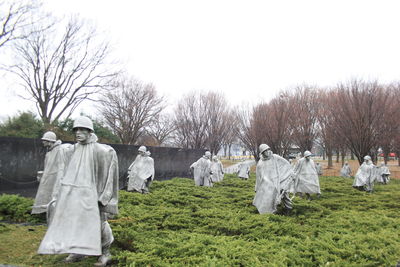 Rear view of man standing in front of bare trees