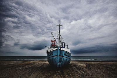 Sailboat on beach against sky