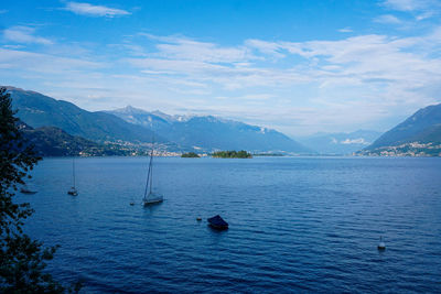 Scenic view of sea by mountains against sky