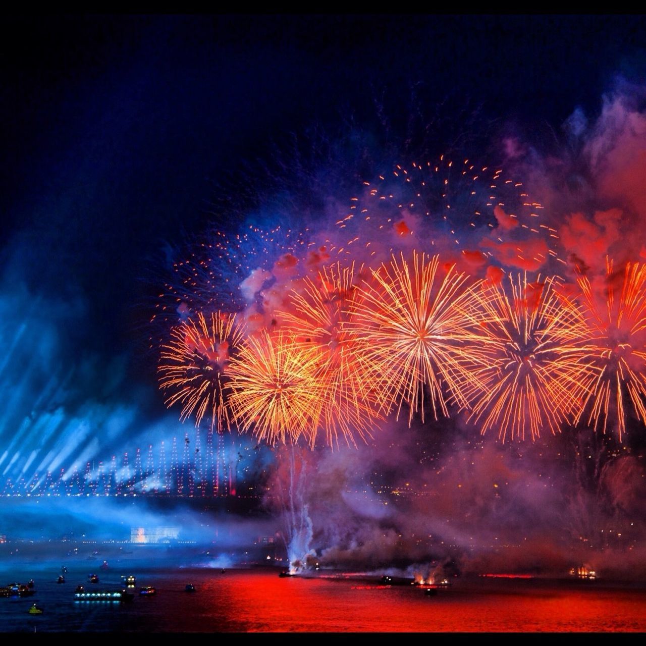 night, illuminated, firework display, long exposure, exploding, celebration, firework - man made object, motion, sparks, firework, sky, glowing, arts culture and entertainment, event, blurred motion, entertainment, multi colored, water, low angle view, orange color