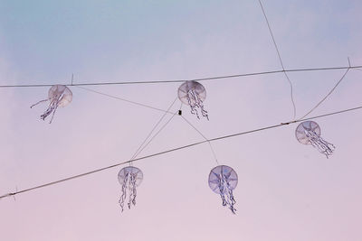 Low angle view of cables hanging against sky