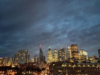 Illuminated buildings in city against sky at night