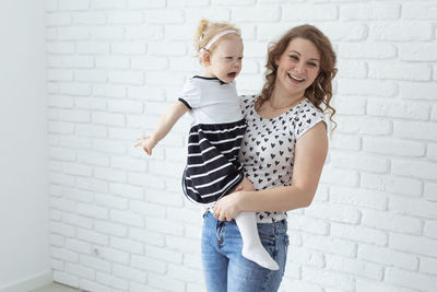 Young woman standing against wall