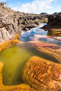 Scenic view of rocks in lake against sky