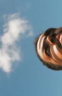 Low angle view of person against blue sky