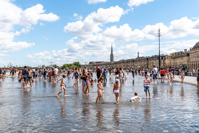 Group of people in water against sky