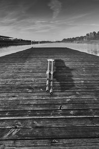 Boardwalk on pier over sea against sky