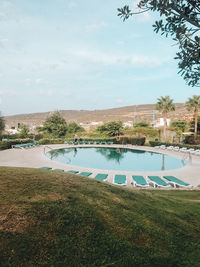 Swimming pool by lake against sky