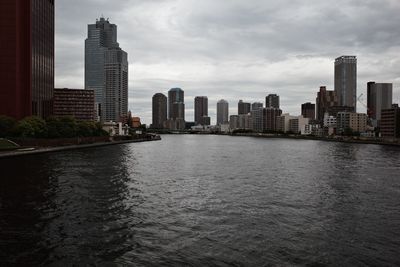 River amidst buildings in city against sky