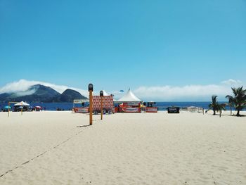 People at beach against blue sky