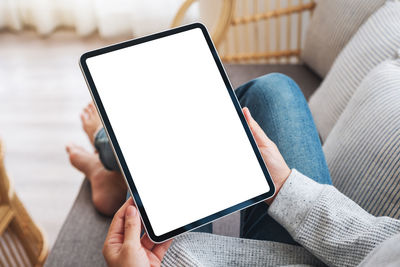 Midsection of woman using digital tablet