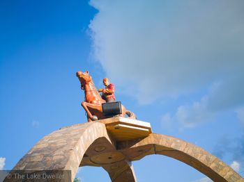 Low angle view of man against blue sky