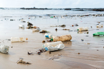 Garbage on beach by sea against sky