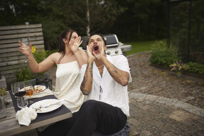 Happy friends sitting at table