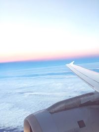 Close-up of airplane wing over sea against sky