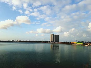 Scenic view of city by sea against sky