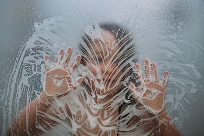 Close-up of human hand on glass window