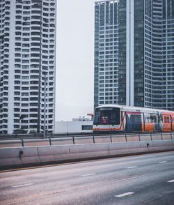 Cars on road by buildings in city