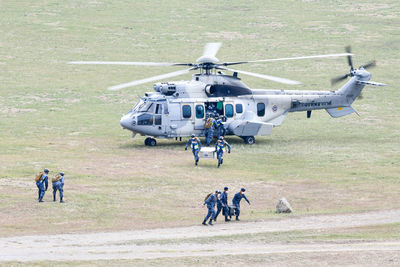 Soldiers carrying equipment from helicopter