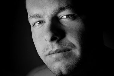 Close-up portrait of man in darkroom