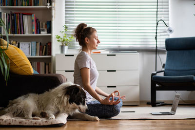Side view of woman meditating at home