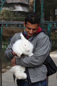 Close-up of young man holding rabbit