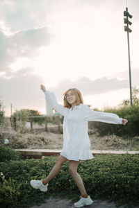 Full length of young woman standing on field