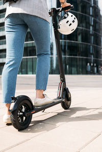 Cropped shot of unrecognizable businesswoman driving electric scooter in the city	