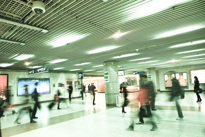 Blurred motion of people walking in illuminated city