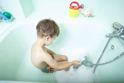 Full length of shirtless boy playing in water