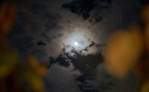 Low angle view of illuminated moon against sky at night