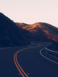 Road by mountain against clear sky