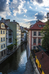 Canal amidst buildings in town against sky
