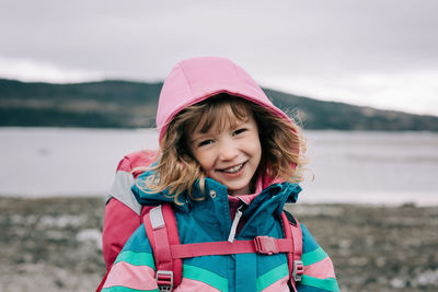 Close up candid portrait of young girl laughing whilst hiking