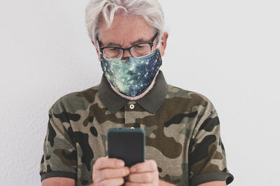 Portrait of man using smart phone against white background