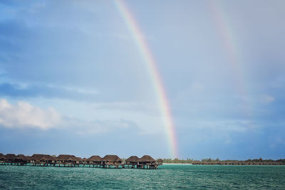 Double rainbow over huts in bora bora - huts in the ocean - rainbow after a storm