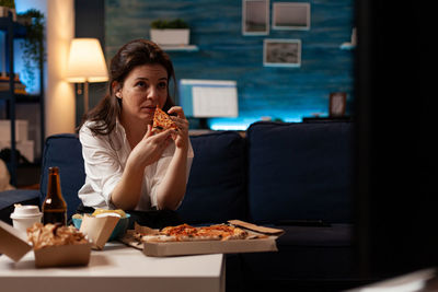 Young woman eating food in restaurant