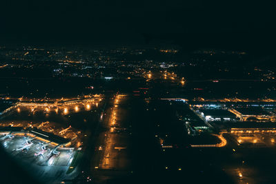 Illuminated cityscape against sky at night