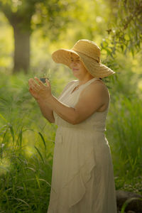 Woman holding umbrella standing on field