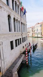 Boats in canal amidst buildings in city