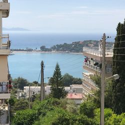 High angle view of cityscape by sea against sky