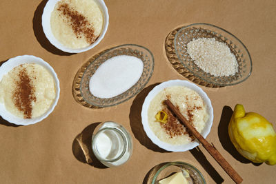 Rice pudding with its ingredients on a brown background