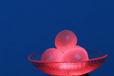 Close-up of red fruit on table against blue background